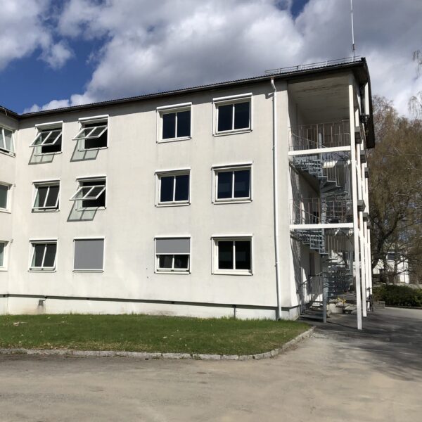 Sunnaas sykehus, hvit bygning med rømningstrapp. Ingenia var rådgivende ingeniør for energi, miljø og bygningsfysikk